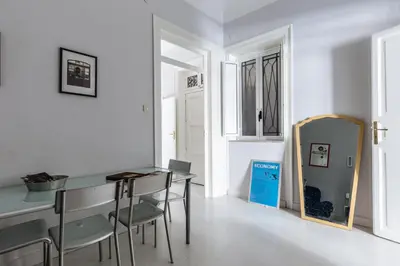 a dining room with a table and chairs and a mirror at Casa Dante with Balcony by Wonderful Italy in Palermo