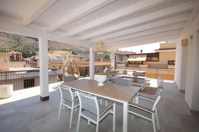 a patio with a wooden table and chairs on a deck at Al Covo dei Mori in Bagheria