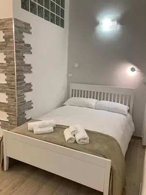 a bedroom with a bed with towels on it at Teatro Apartments Giardino Inglese in Palermo