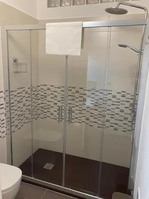 a glass shower in a bathroom with a toilet at Teatro Apartments Giardino Inglese in Palermo