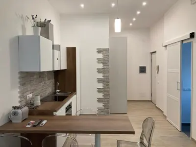 a kitchen with a table and chairs in a room at Teatro Apartments Giardino Inglese in Palermo
