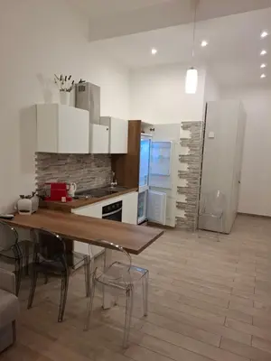 a kitchen with a table and chairs in a room at Teatro Apartments Giardino Inglese in Palermo
