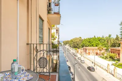 a table on a balcony with a view of a street at Un balcone sull'Orto Botanico by Wonderful Italy in Palermo
