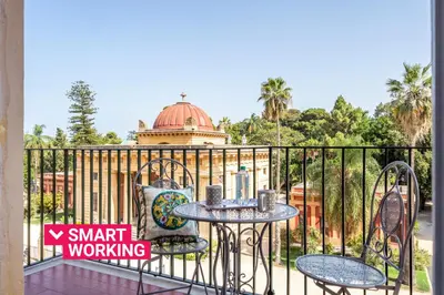 a balcony with a table and chairs on a fence at Un balcone sull'Orto Botanico by Wonderful Italy in Palermo