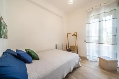 a bedroom with a bed with blue pillows and a window at Un balcone sull'Orto Botanico by Wonderful Italy in Palermo