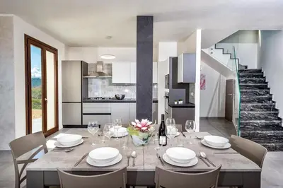 a kitchen and dining room with a table and chairs at Villa Monica in Scopello