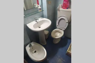 a bathroom with a white toilet and a sink at Fra la città storica e quella ottocentesca in Palermo