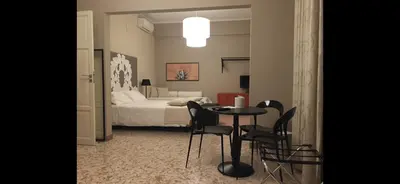a bedroom with a bed and a table and chairs at Due Cani in Palermo