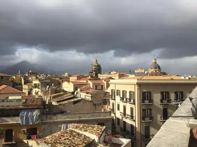 a view of a city with storm clouds in the background at Due Cani in Palermo