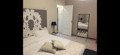 a bedroom with a white bed and a mirror at Due Cani in Palermo