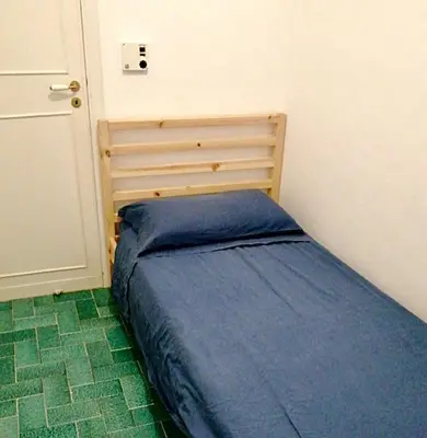 a small bedroom with a blue bed in a room at Luxury Villa just 50 mt from the beach, 10 minutes from the airport in Carini
