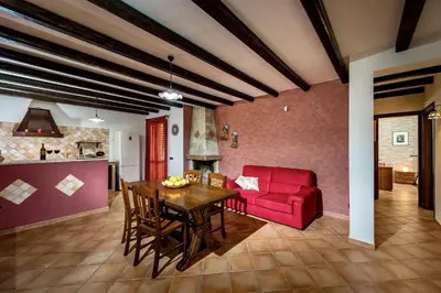 a living room with a red couch and a table at Villa Giuliana in Castellammare del Golfo