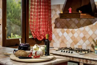 a kitchen counter with a bottle of wine and vegetables at Villa Giuliana in Castellammare del Golfo