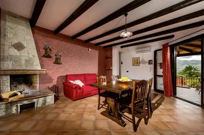 a living room with a table and a red couch at Villa Giuliana in Castellammare del Golfo