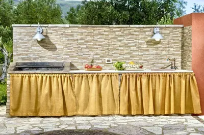 a table with a yellow table cloth next to a brick wall at Villa Giuliana in Castellammare del Golfo