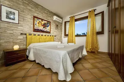 a bedroom with a large bed and a window at Villa Giuliana in Castellammare del Golfo