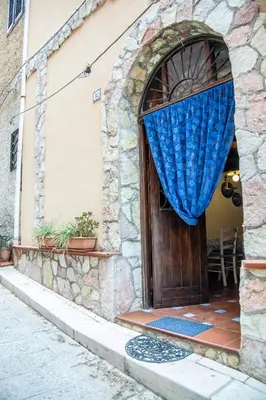 a door to a building with a blue curtain on it at Nassa Apartment in Trappeto