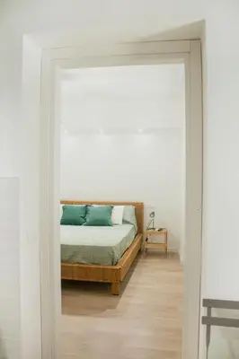 a bedroom with a bed in a white room at Vicolo del Salto in Palermo