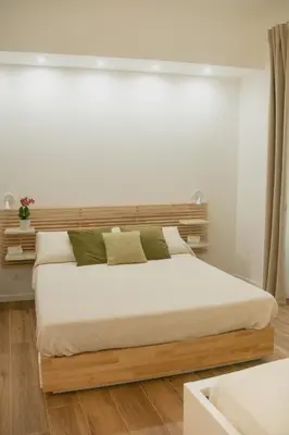 a bedroom with a bed with white sheets and green pillows at Vicolo del Salto in Palermo