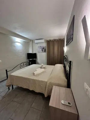 a bedroom with a bed with a remote control on it at Case Vacanze Seggettieri in Palermo