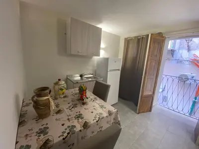 a small kitchen with a table and a refrigerator at Case Vacanze Seggettieri in Palermo