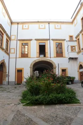 a building with a courtyard with flowers in front of it at Home Resuttano in Palermo