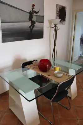 a dining table with a glass top in a room at Home Resuttano in Palermo
