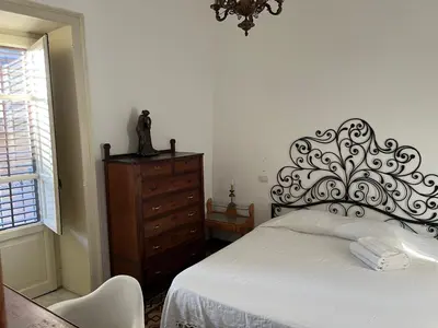 a bedroom with a white bed and a dresser at FraLePorte Vintage Apartment in Palermo