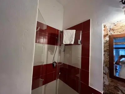 a bathroom with a shower with red and white tiles at FraLePorte Vintage Apartment in Palermo