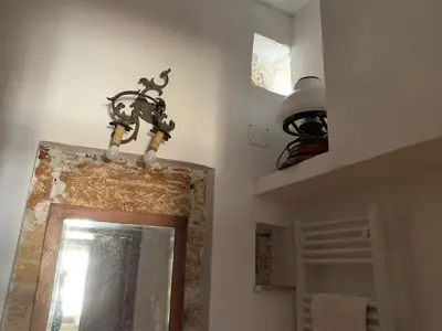 a chandelier hanging over a mirror in a bathroom at FraLePorte Vintage Apartment in Palermo