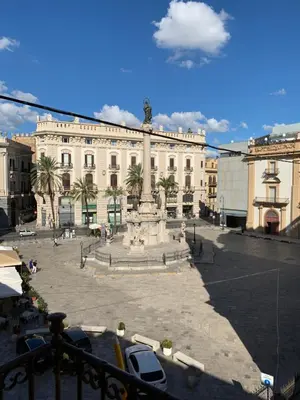 a large building with a fountain in front of it at FraLePorte Vintage Apartment in Palermo