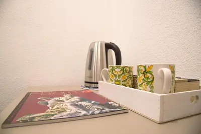 a table with two mugs and a tea kettle at Barlaman Luxury Rooms in Palermo