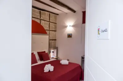 a bedroom with a red bed with towels on it at Barlaman Luxury Rooms in Palermo