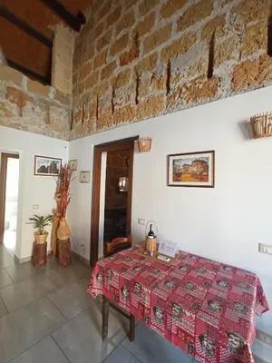 a room with a table and a brick wall at ZyZ Apartments La Kalsa in Palermo