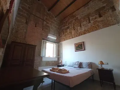 a bedroom with a bed and a brick wall at ZyZ Apartments La Kalsa in Palermo