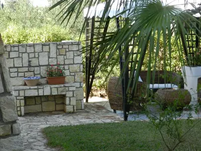 a garden with a stone wall and some plants at Scopello sul mare 1 in Castellammare del Golfo