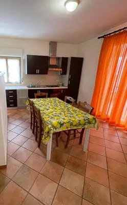 a kitchen with a table with a yellow table cloth at Scopello sul mare 1 in Castellammare del Golfo