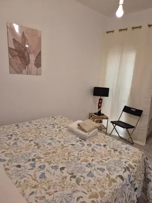 a bedroom with a bed and a chair and a lamp at La casuzza 1 in Palermo