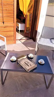 a table with two plates on top of it on a patio at Pozzo Antico Apartments in San Vito lo Capo