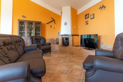a living room with couches and a tv and a fireplace at Villa Romitello con Piscina Total Relax in Borgetto