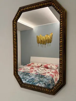 a mirror on a wall with a bed in a room at Dimora Palermo with private pool in Palermo