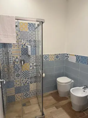 a bathroom with a shower and a toilet and a sink at Dimora Palermo with private pool in Palermo