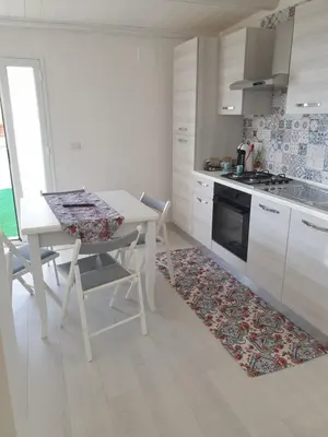 a kitchen with a table and chairs and a stove at CASA DEL SOLE in Alcamo