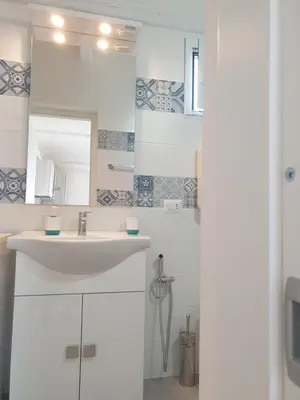 a white bathroom with a sink and a mirror at CASA DEL SOLE in Alcamo