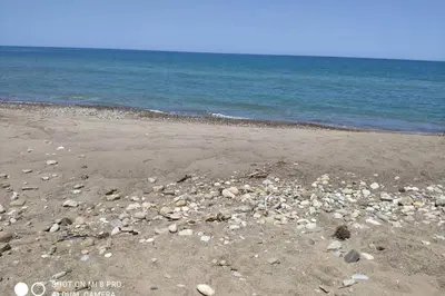 a beach with rocks on the sand and water at Sul mare con spiaggetta privata vicino a Cefalù. in Buonfornello