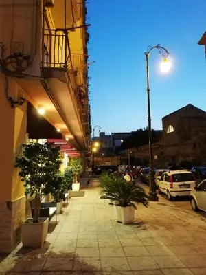 a sidewalk with potted plants and a street light at Casa Magione in Palermo