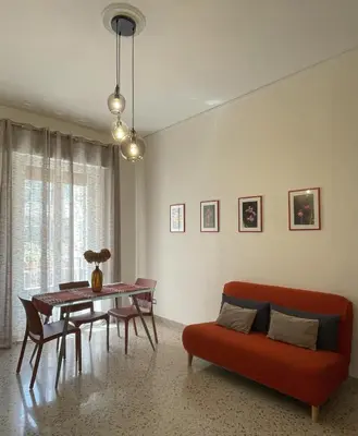 a living room with a red couch and a table at Casa Magione in Palermo