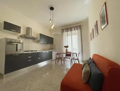 a kitchen and living room with a couch and a table at Casa Magione in Palermo