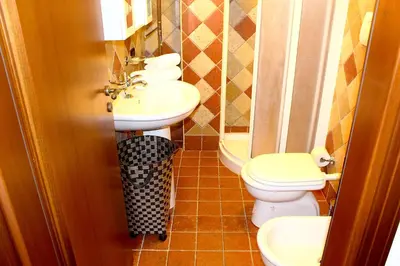a bathroom with two toilets and a sink at Casale Orioles in Torretta