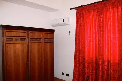 a room with a red curtain and a closet at Casale Orioles in Torretta